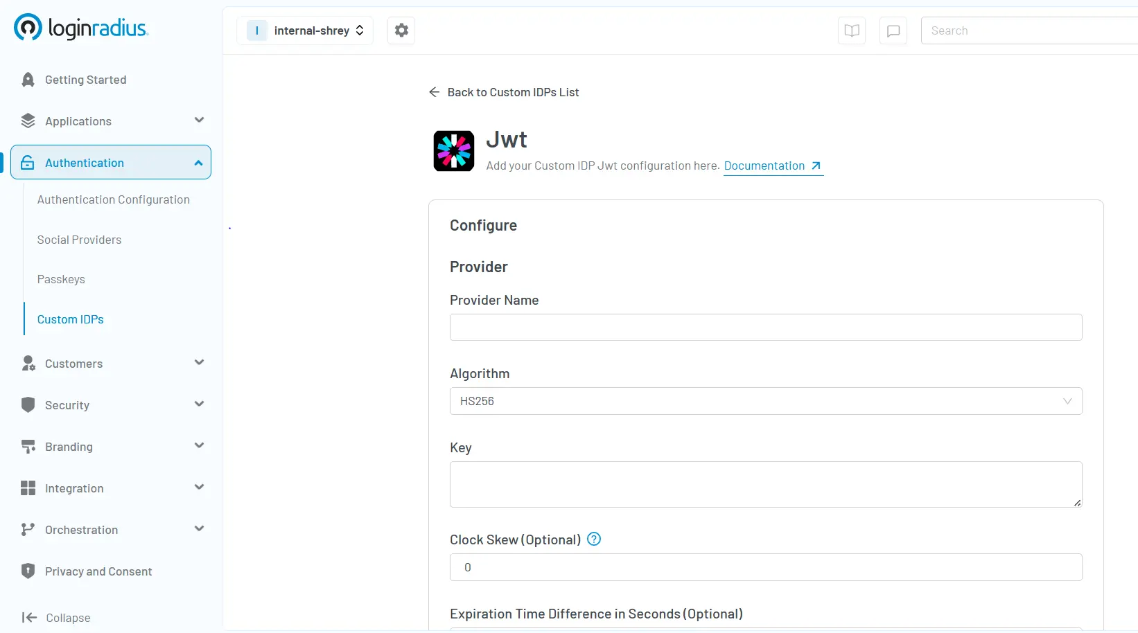 Screenshot of LoginRadius Admin Console showing JWT Custom IDP configuration interface with options for provider name, algorithm (HS256), key entry, clock skew, and expiration time settings.